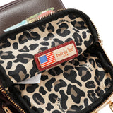 Face : Petit sac bandoulière Nicole Lee à motif Londres, vue de face
Porté : Femme portant le sac Nicole Lee Londres en bandoulière
Intérieur : Compartiments intérieurs du petit sac Nicole Lee Londres
Détail : Plaque logo à strass et finitions argentées du sac Nicole Lee